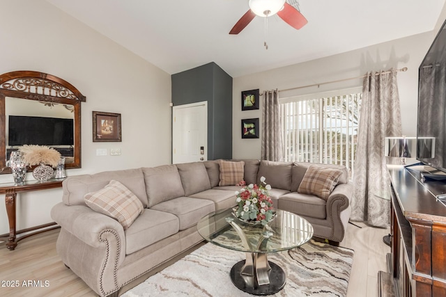 living room with ceiling fan, light wood-type flooring, and vaulted ceiling