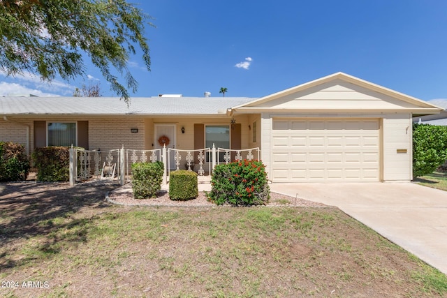 ranch-style home with an attached garage, concrete driveway, and brick siding