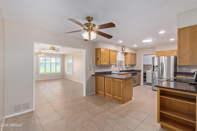 kitchen with sink, light tile patterned floors, appliances with stainless steel finishes, ceiling fan, and kitchen peninsula