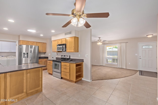 kitchen featuring ceiling fan, appliances with stainless steel finishes, independent washer and dryer, and light carpet