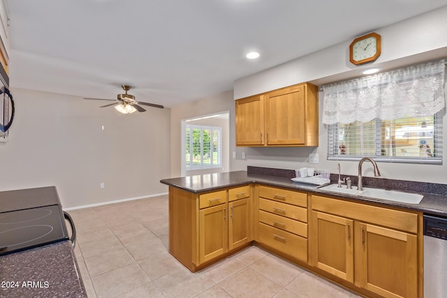 kitchen featuring light tile patterned floors, stainless steel dishwasher, a ceiling fan, a sink, and a peninsula