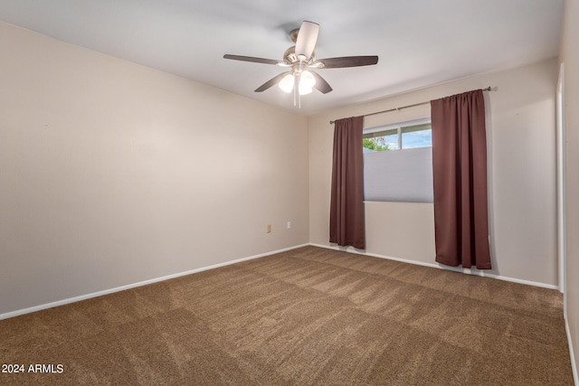 carpeted empty room with a ceiling fan and baseboards