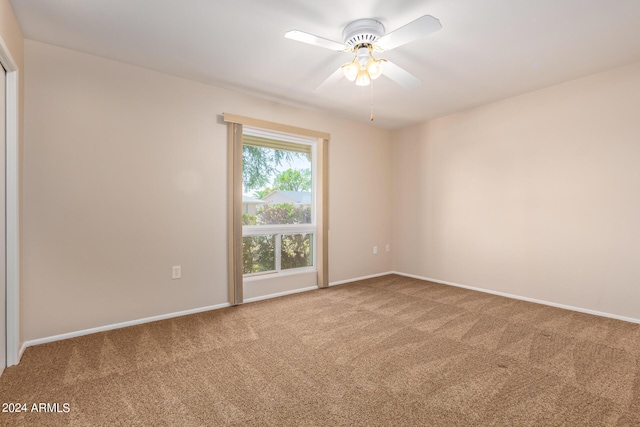 empty room featuring carpet floors, a ceiling fan, and baseboards