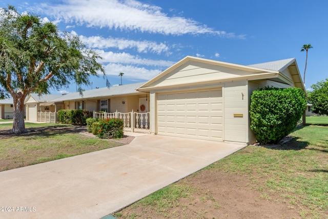 ranch-style home featuring a front lawn and a garage