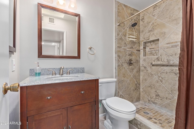 bathroom featuring toilet, a shower stall, visible vents, and vanity