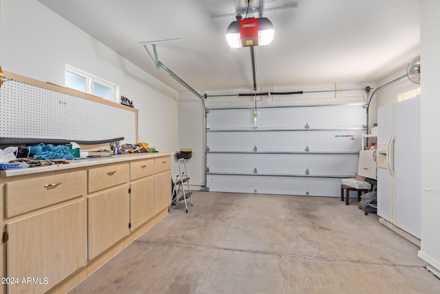 garage with a garage door opener and white refrigerator with ice dispenser