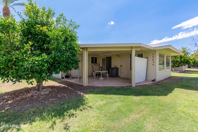 back of house featuring a lawn and a patio