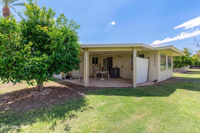 rear view of house featuring a patio area and a lawn