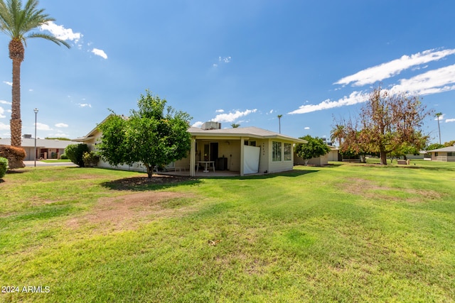 back of property with a patio area and a yard