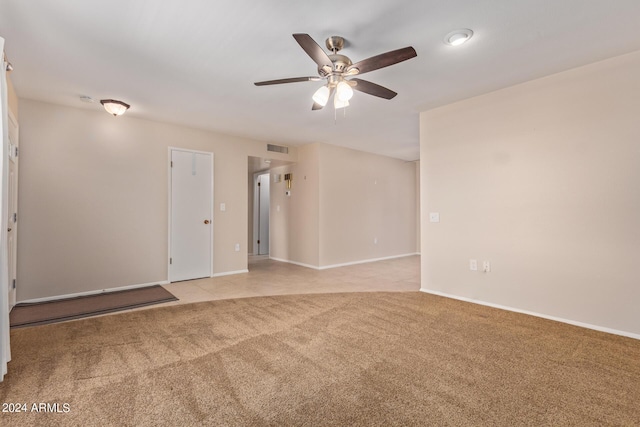 empty room with baseboards, a ceiling fan, visible vents, and light colored carpet