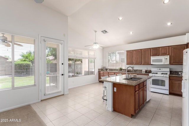 7231 W Lone Cactus Dr, Glendale, AZ 85308 - kitchen with white appliances, a sink, a ceiling fan, light stone counters, and a center island with sink