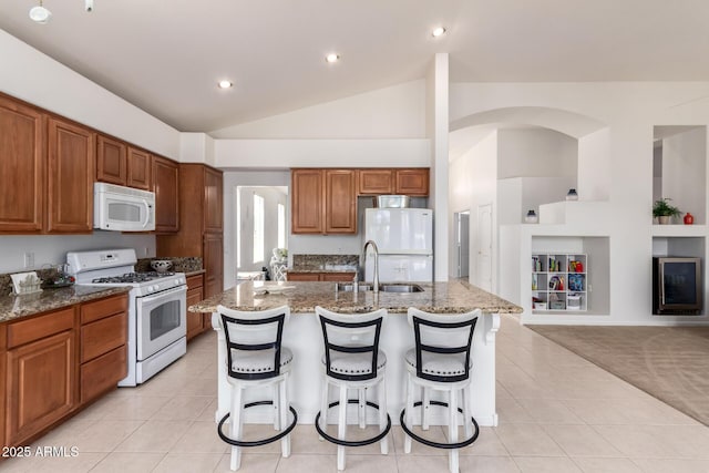 7231 W Lone Cactus Dr, Glendale, AZ 85308 - kitchen with white appliances, a sink, light tile patterned flooring, light stone counters, and lofted ceiling