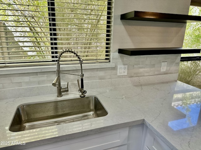 2138 E Williams Dr, Phoenix, AZ 85024 - kitchen view of a sink, backsplash, white cabinetry, and light stone countertops