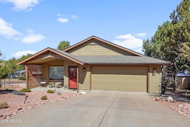 ranch-style home featuring driveway, roof with shingles, and an attached garage