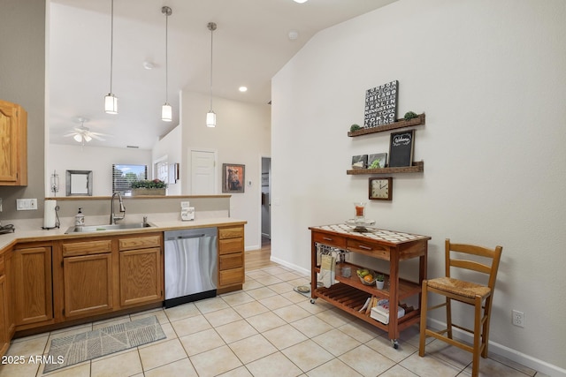 kitchen with light tile patterned floors, ceiling fan, a peninsula, stainless steel dishwasher, and a sink