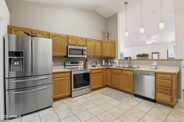 kitchen featuring pendant lighting, light tile patterned floors, light countertops, appliances with stainless steel finishes, and a sink