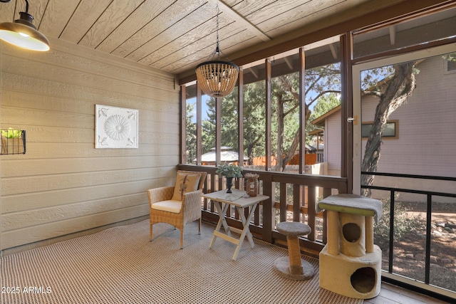 sunroom / solarium featuring a chandelier and wooden ceiling