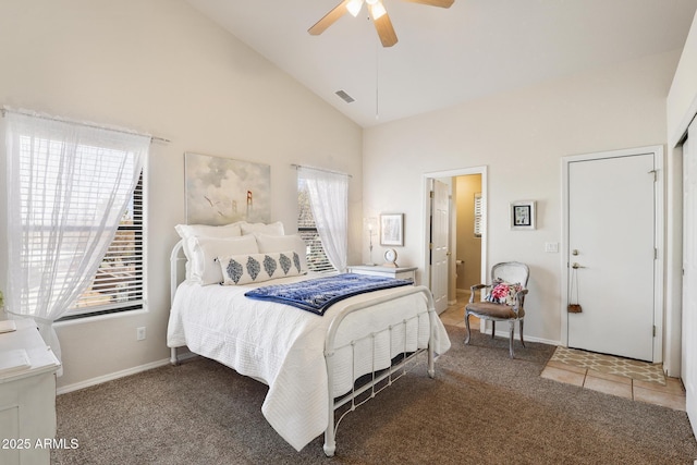 carpeted bedroom featuring high vaulted ceiling, baseboards, visible vents, and a ceiling fan