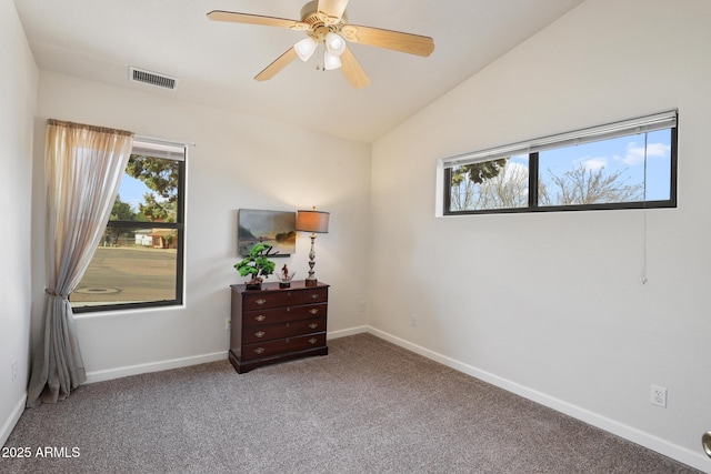 carpeted spare room featuring a ceiling fan, lofted ceiling, visible vents, and baseboards