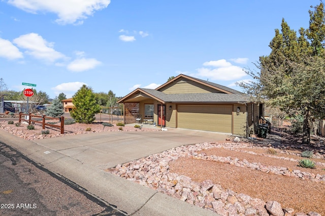 single story home featuring driveway, a shingled roof, and a garage