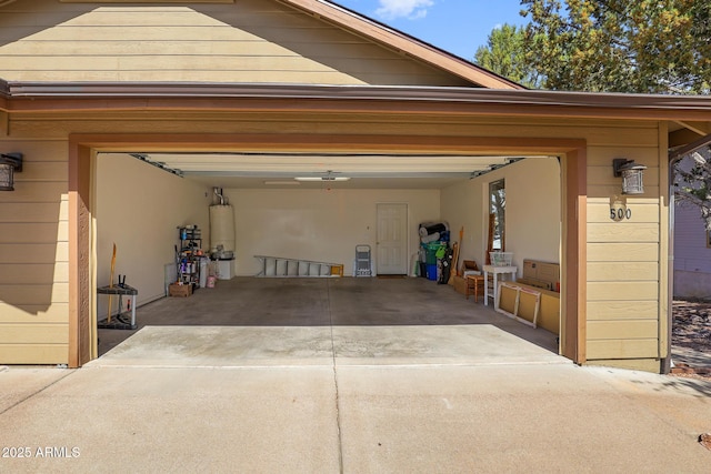 garage featuring driveway and water heater