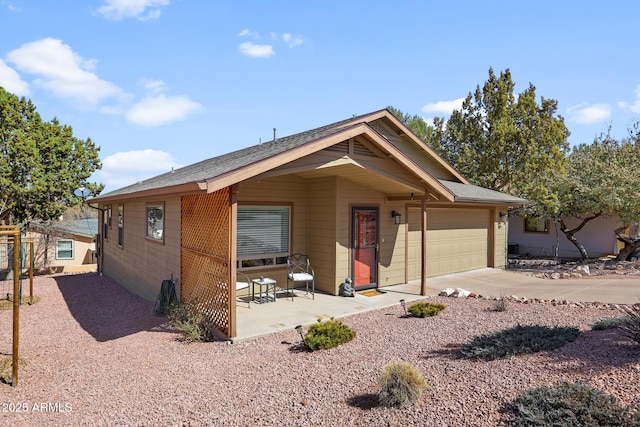 view of front of house with a garage, concrete driveway, and a patio