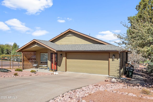 view of front of property with driveway, an attached garage, fence, and a shingled roof