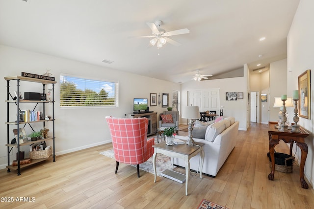 living area featuring lofted ceiling, ceiling fan, light wood-style flooring, visible vents, and baseboards