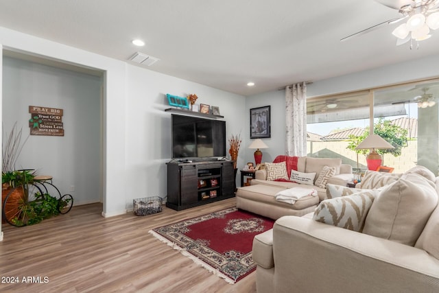 living room featuring hardwood / wood-style floors and ceiling fan