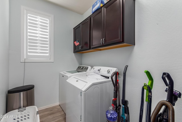 laundry room featuring cabinets, separate washer and dryer, and light hardwood / wood-style flooring