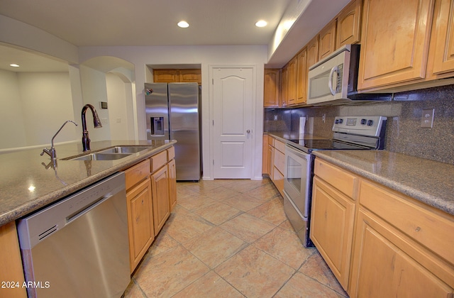 kitchen with decorative backsplash, stainless steel appliances, sink, and light tile patterned floors