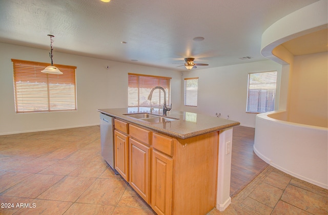 kitchen featuring a center island with sink, sink, decorative light fixtures, stainless steel dishwasher, and ceiling fan