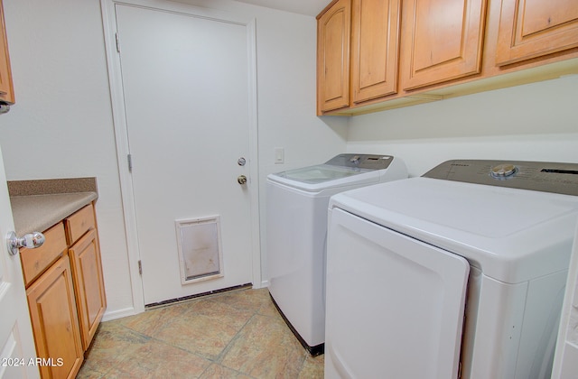 laundry room featuring cabinets and washing machine and dryer