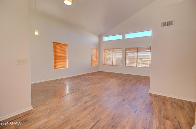 empty room featuring hardwood / wood-style flooring and high vaulted ceiling