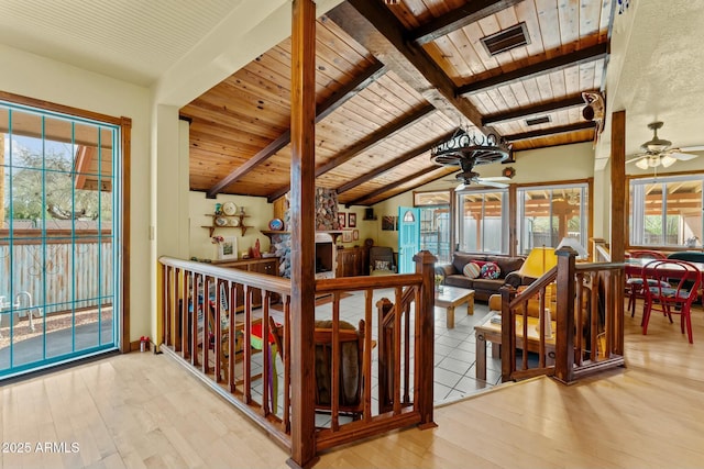 interior space featuring visible vents, lofted ceiling with beams, wooden ceiling, wood finished floors, and an upstairs landing