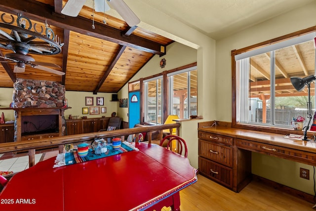 recreation room featuring a ceiling fan, wooden ceiling, vaulted ceiling with beams, light wood-type flooring, and a fireplace