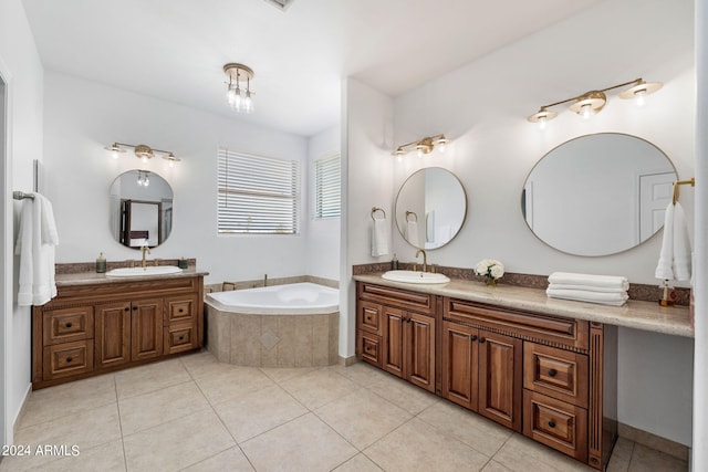 bathroom with vanity, tile patterned flooring, and a relaxing tiled tub