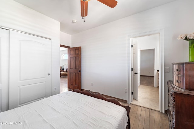 bedroom with ceiling fan, a closet, and light hardwood / wood-style floors