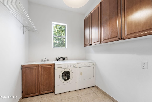 laundry area featuring sink, cabinets, separate washer and dryer, and light tile patterned floors