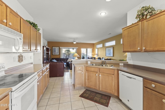 kitchen with light tile patterned floors, a peninsula, white appliances, a sink, and open floor plan