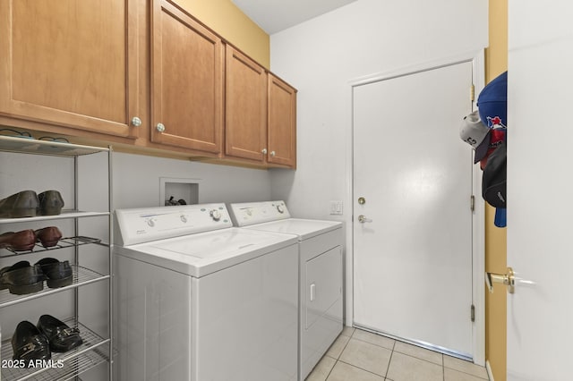 laundry area featuring cabinet space, independent washer and dryer, and light tile patterned floors