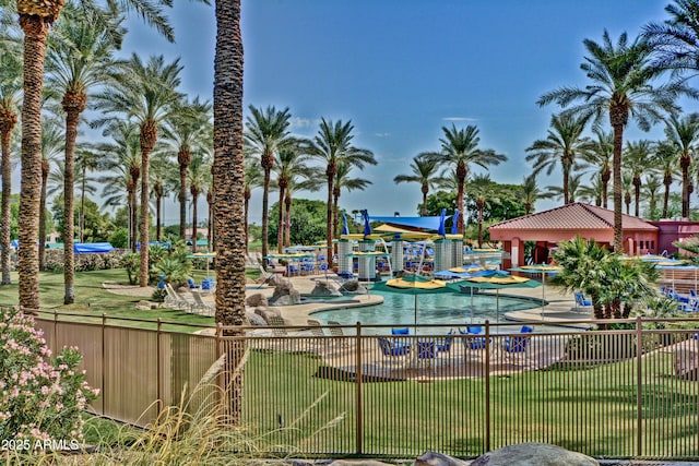 view of swimming pool with fence and a yard