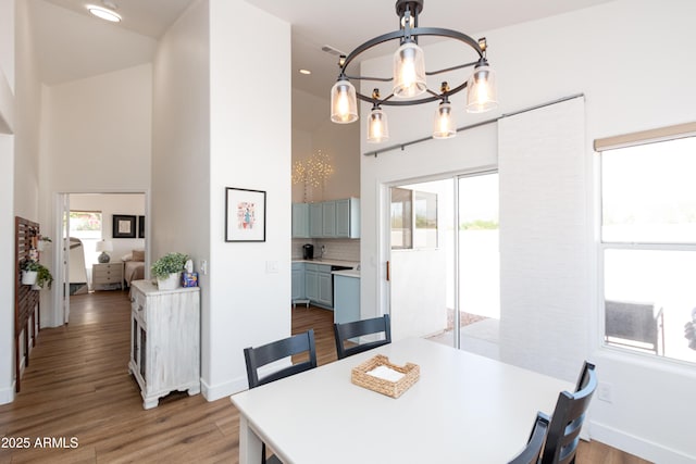 9791 N 118th Way, Scottsdale, AZ 85259 - dining room featuring healthy amount of natural light, a chandelier, a high ceiling, light wood-style floors, and recessed lighting