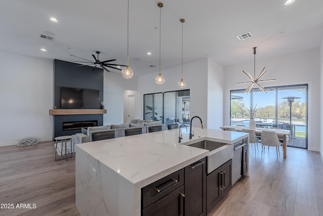 33766 N 86th St, Scottsdale, AZ 85266 - kitchen with a sink, light wood-style flooring, a large fireplace, recessed lighting, and an island with sink