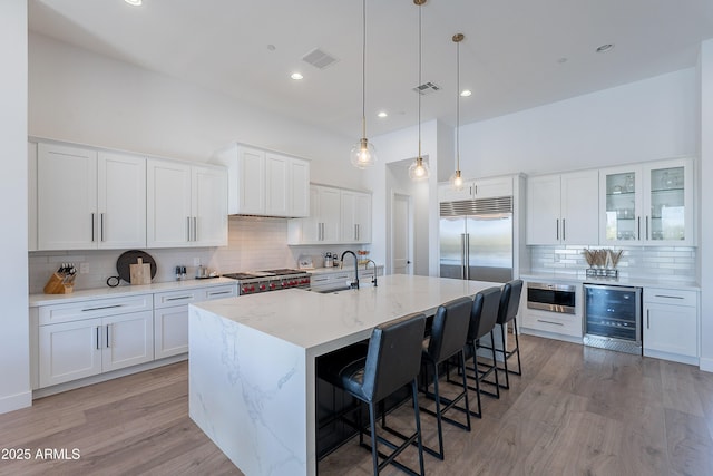 33766 N 86th St, Scottsdale, AZ 85266 - kitchen with beverage cooler, backsplash, a sink, light wood-type flooring, and an island with sink