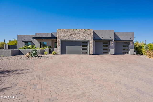 33766 N 86th St, Scottsdale, AZ 85266 - contemporary house with an attached garage, decorative driveway, stone siding, and stucco siding