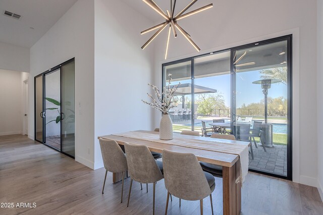 33766 N 86th St, Scottsdale, AZ 85266 - dining area with light wood finished floors, baseboards, a towering ceiling, and a chandelier
