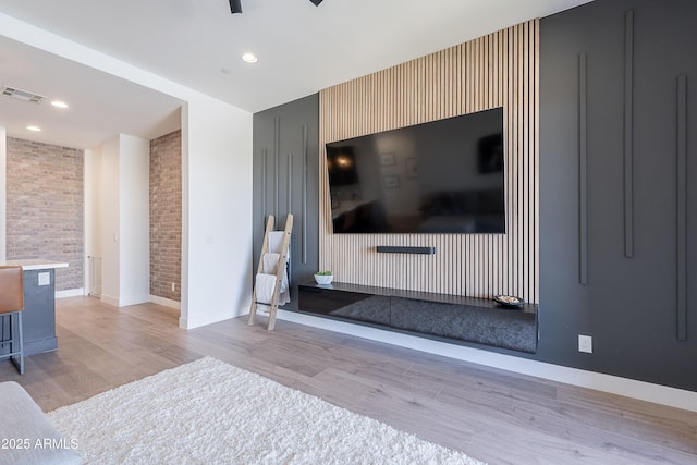 33766 N 86th St, Scottsdale, AZ 85266 - living room with an accent wall, light wood-type flooring, brick wall, baseboards, and recessed lighting