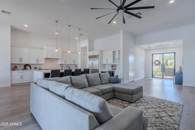 33766 N 86th St, Scottsdale, AZ 85266 - living room featuring ceiling fan, recessed lighting, baseboards, light wood-type flooring, and a high ceiling