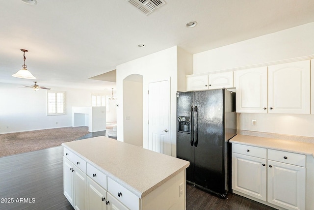 kitchen with white cabinets, hanging light fixtures, dark hardwood / wood-style floors, black fridge with ice dispenser, and ceiling fan